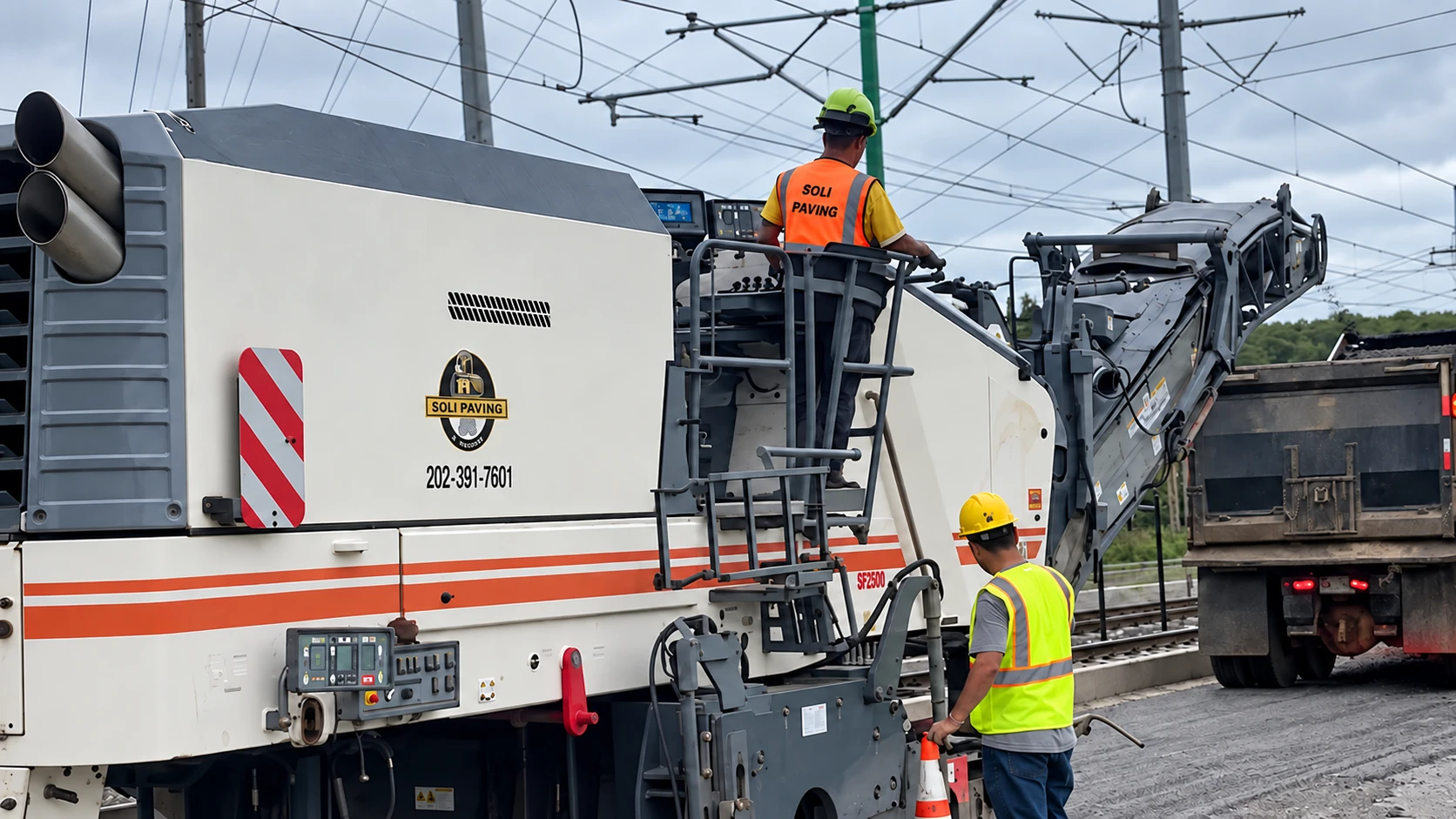 Concrete milling machine operating alongside a work crew