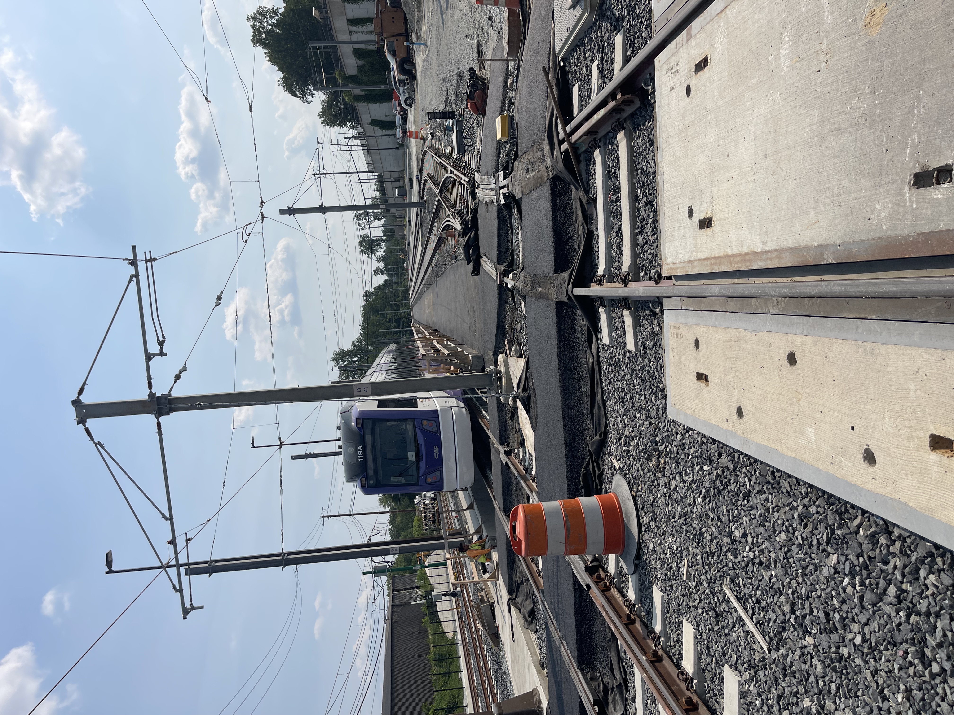 Completed paved trail beside an active rail and infrastructure corridor