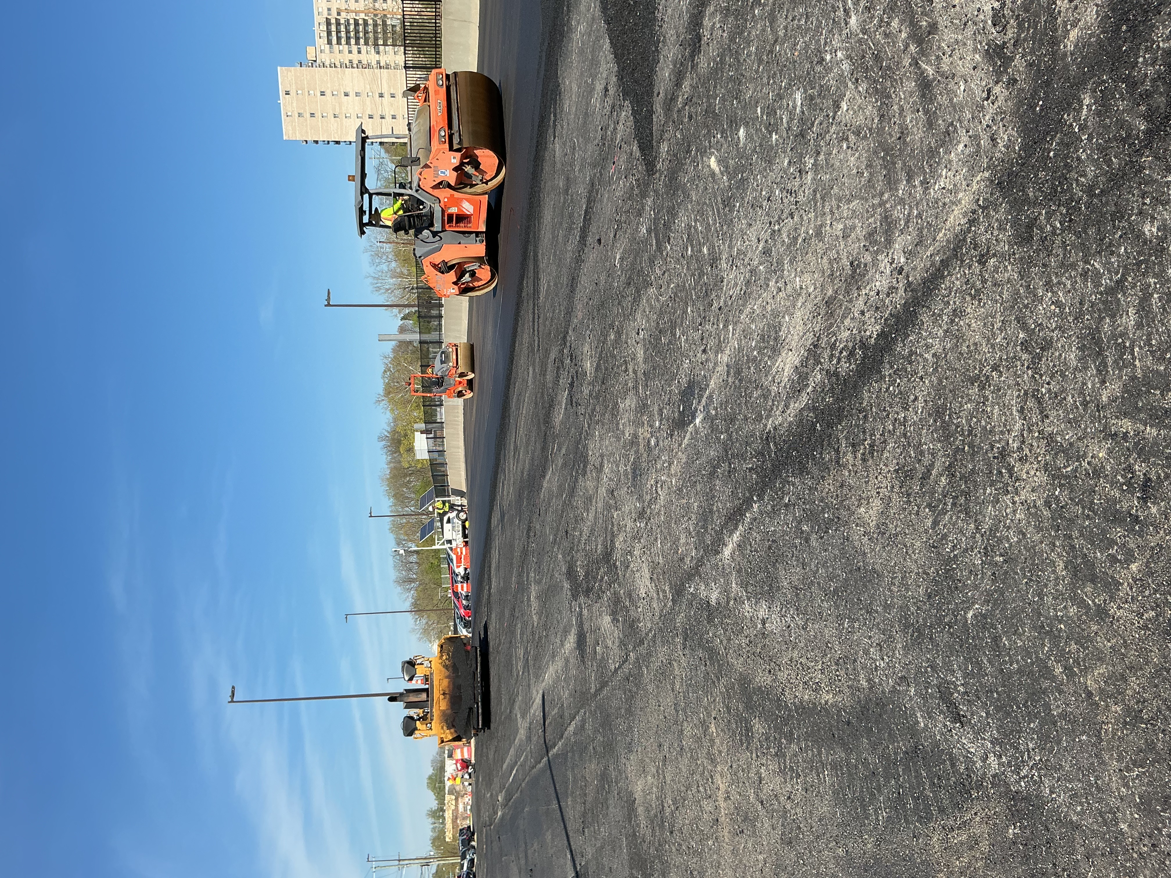 Commercial paving crew compacting a newly placed asphalt surface